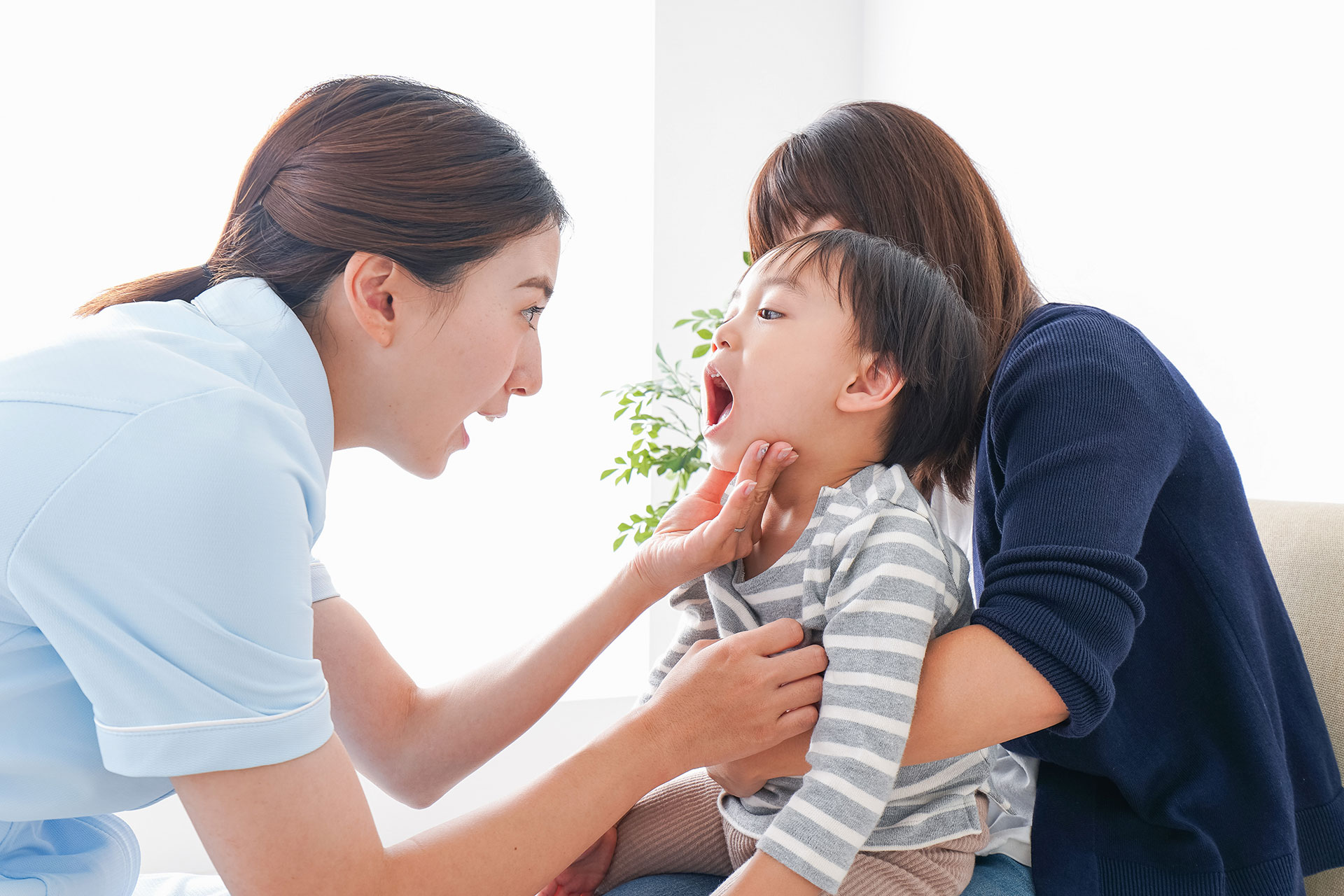 子供の口の中を見る看護師